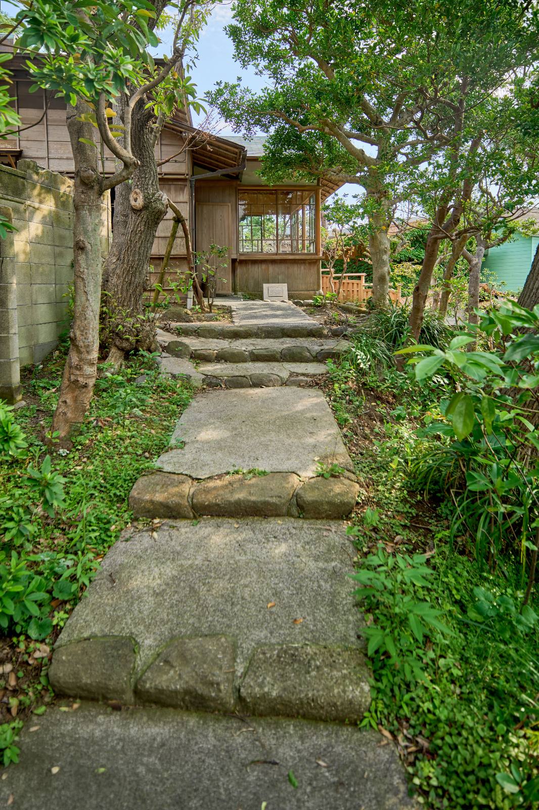 木立のあいだを緩やかに曲がりながら建物へと続くアプローチの坂道。