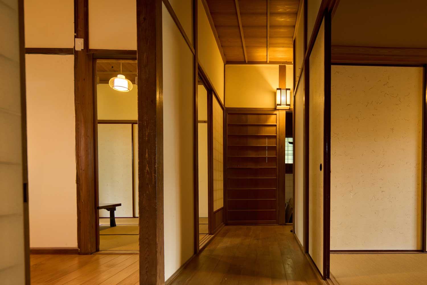 木の床が奥へ続く廊下。部屋ごとの光が変わる。